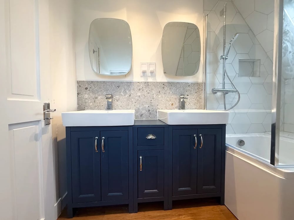 An Aberdeen bathroom completed by Claude’s Tradesmen, with a navy double vanity, chrome taps and a bath shower