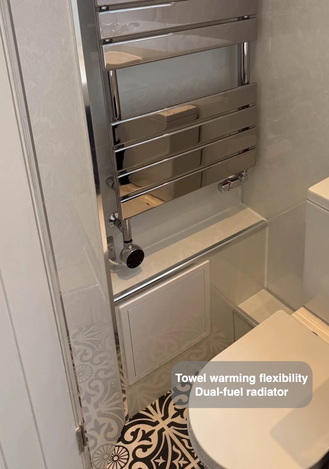 Dual-fuel towel radiator beside toilet