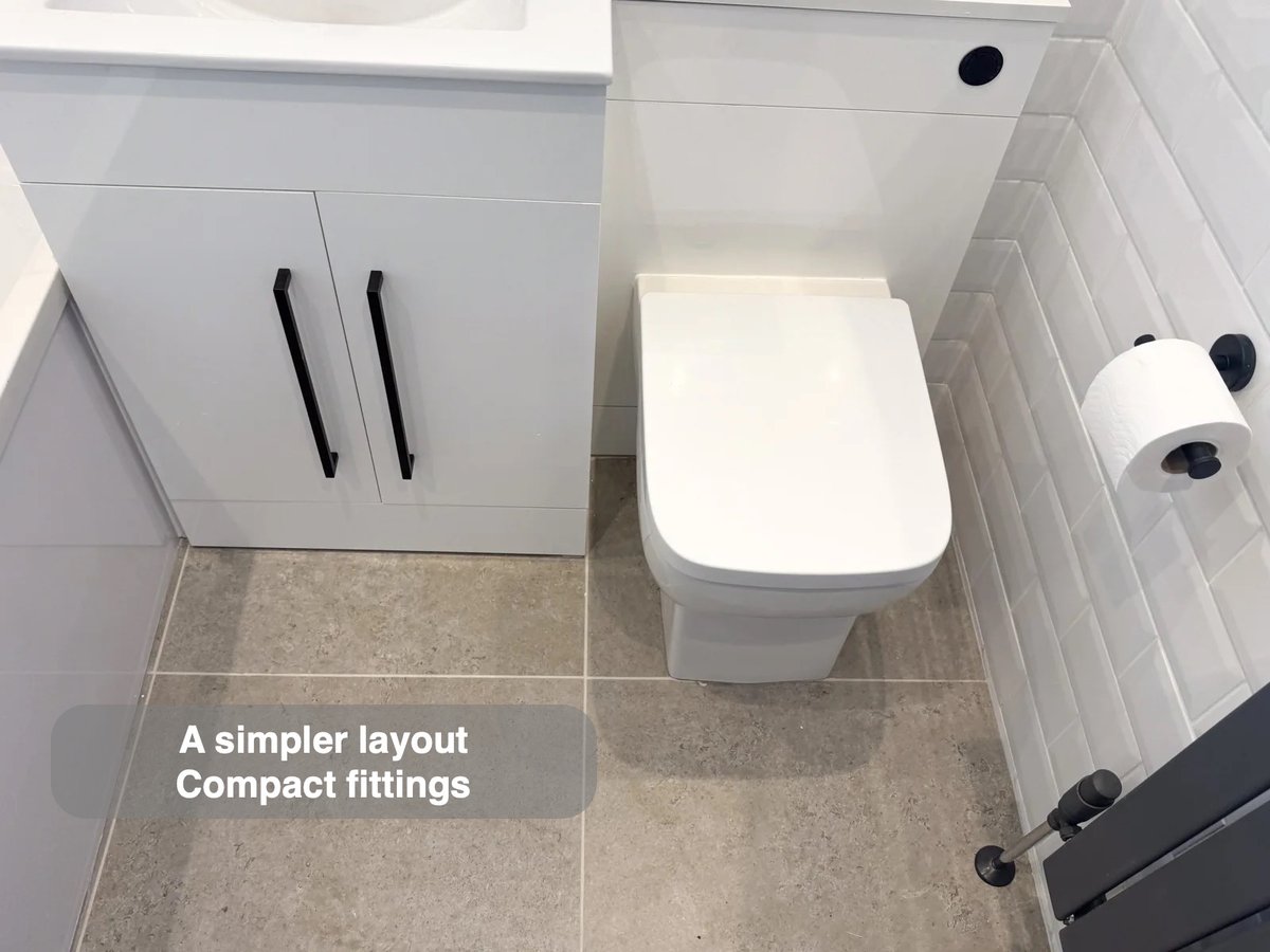 Vanity and toilet within white tiled room