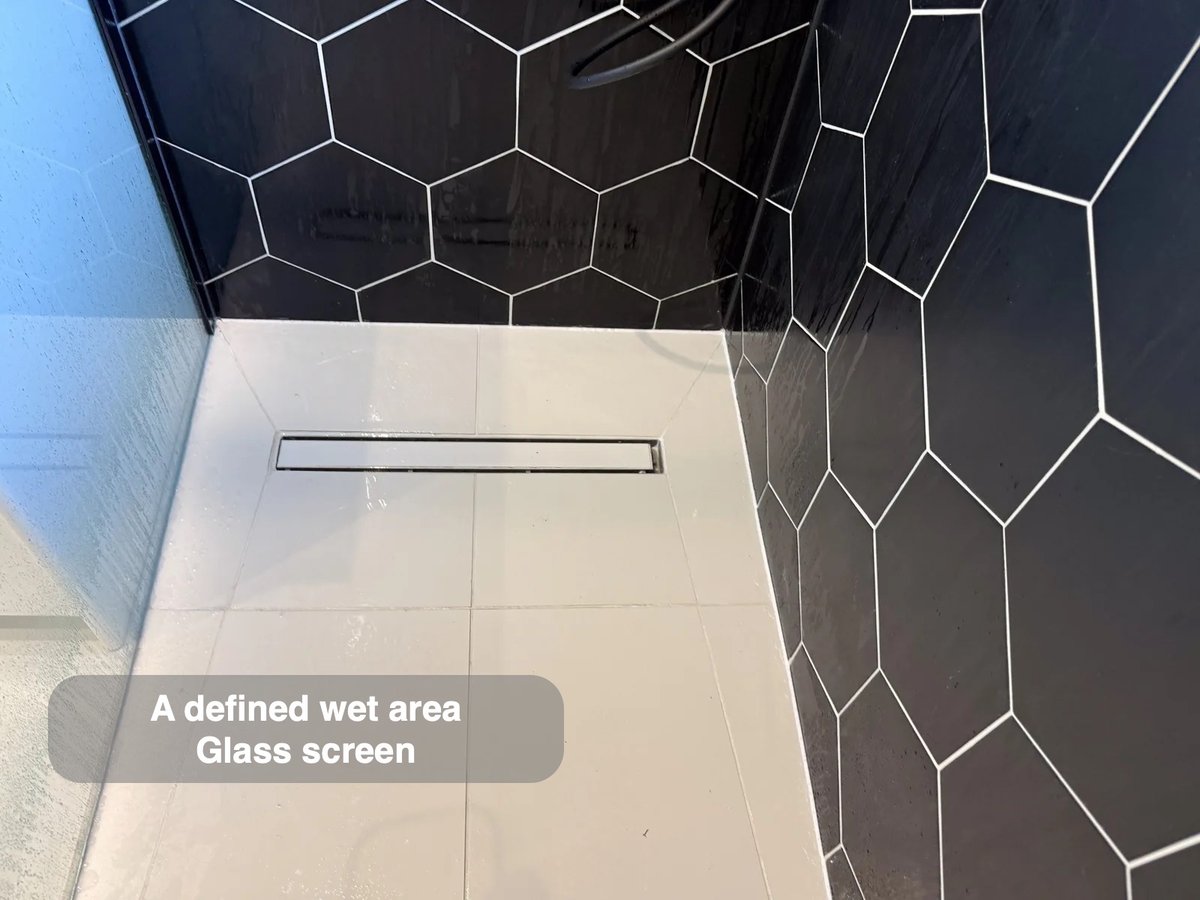 Wetroom floor with linear drain and glass panel