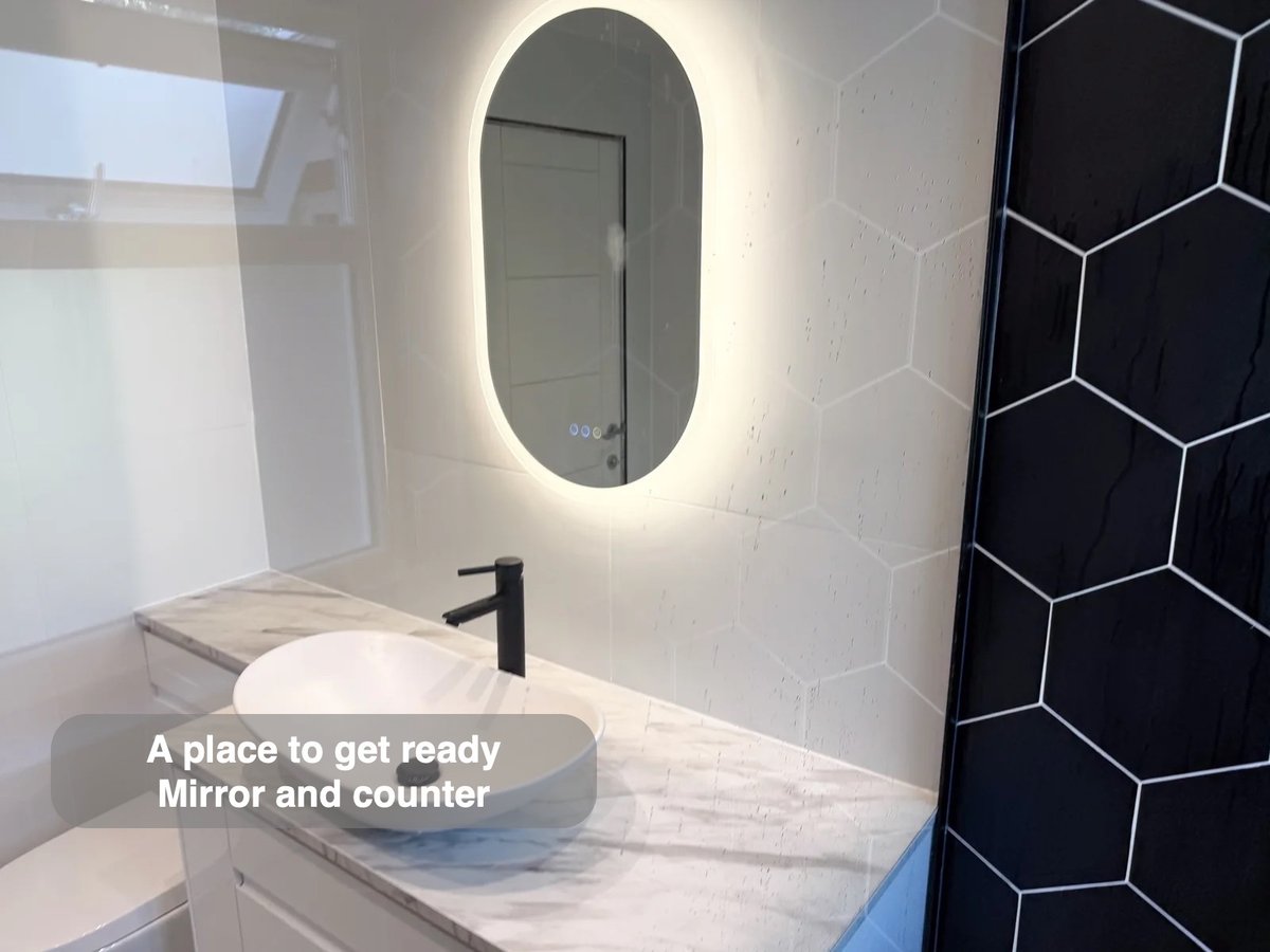 Illuminated mirror above basin counter