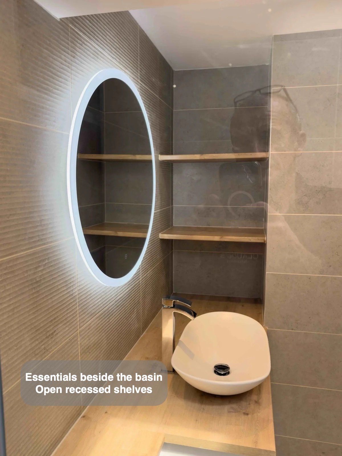 Basin, circular mirror and open shelves
