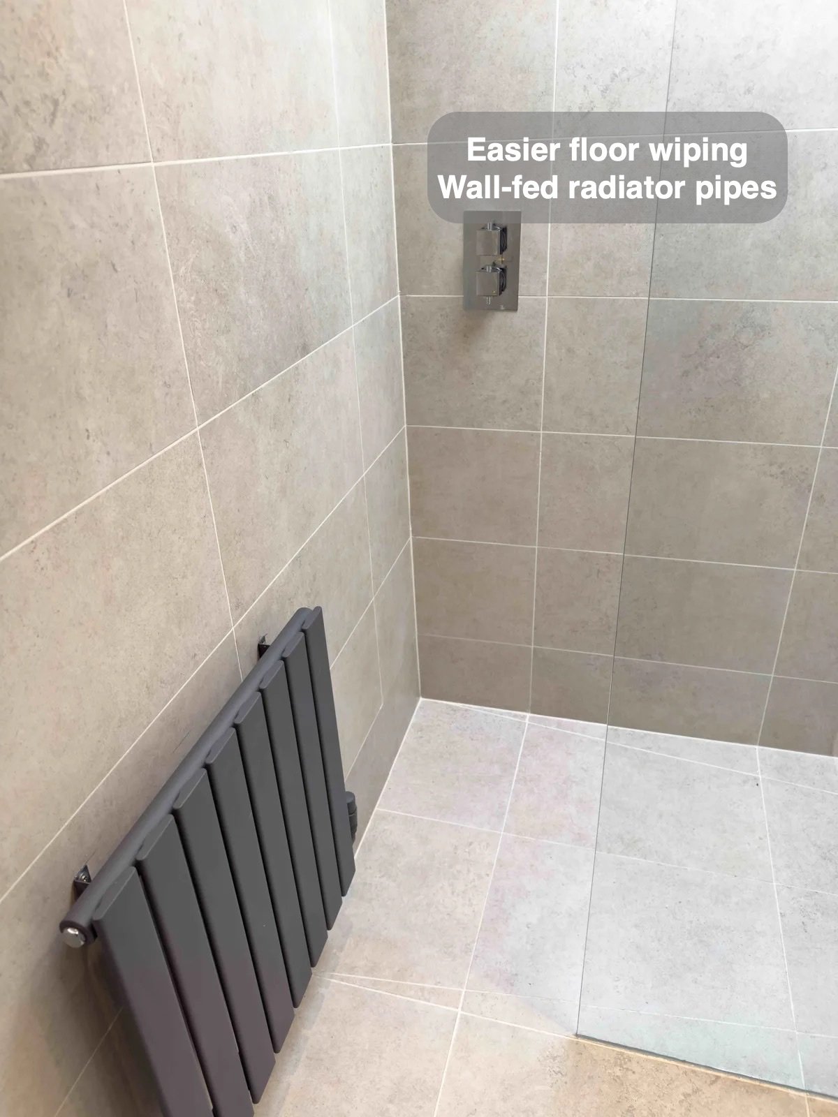 Wall-fed radiator beside tiled shower