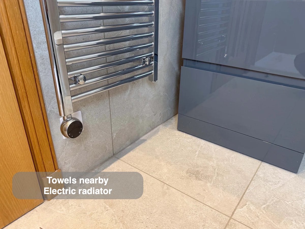 Electric towel radiator beside vanity drawers
