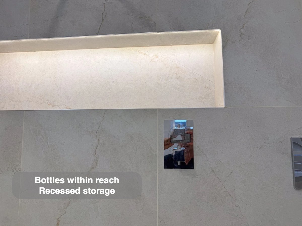 Long illuminated shower recess above concealed controls
