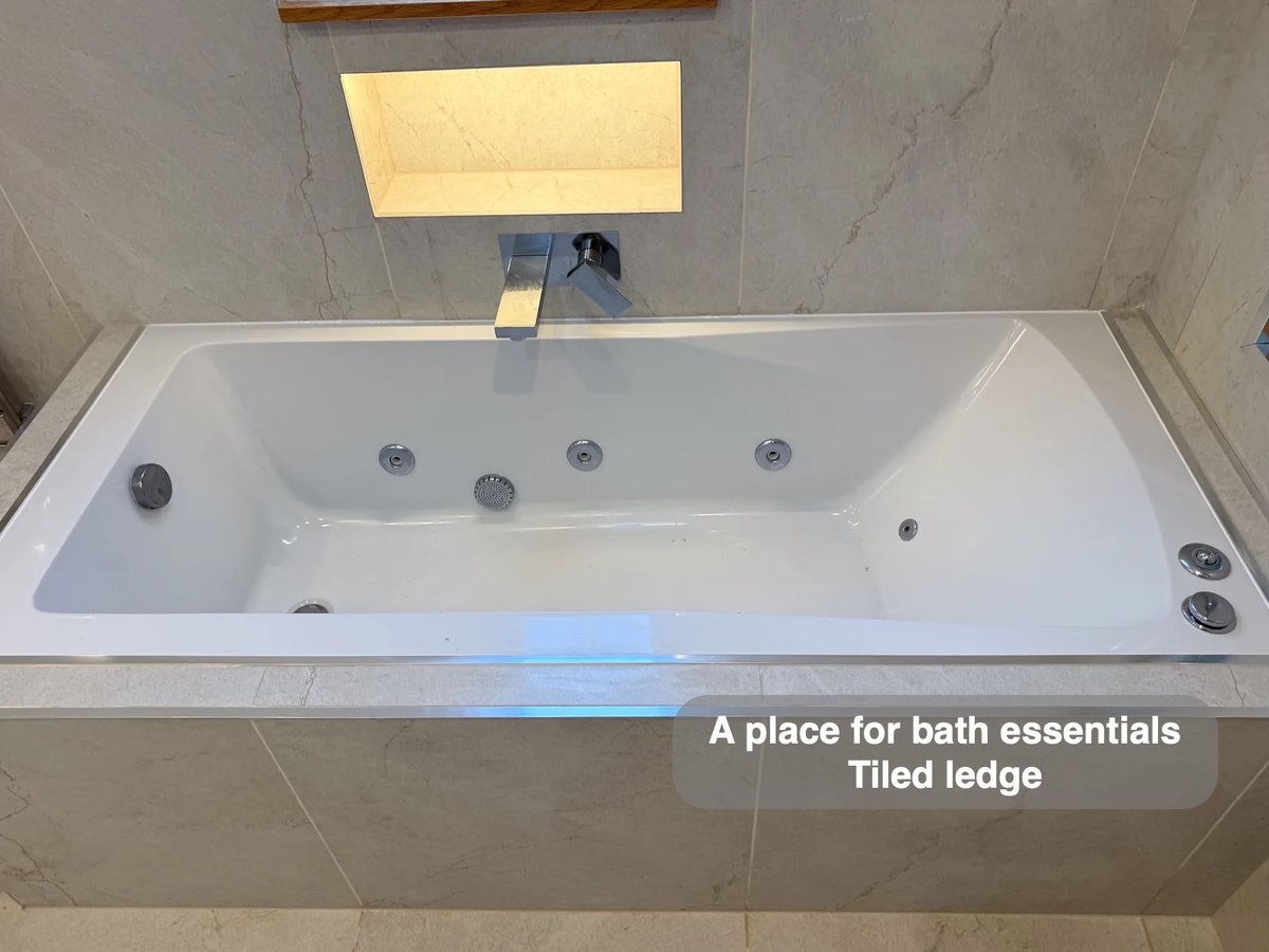 Jacuzzi-style bath with tiled surround and illuminated recess