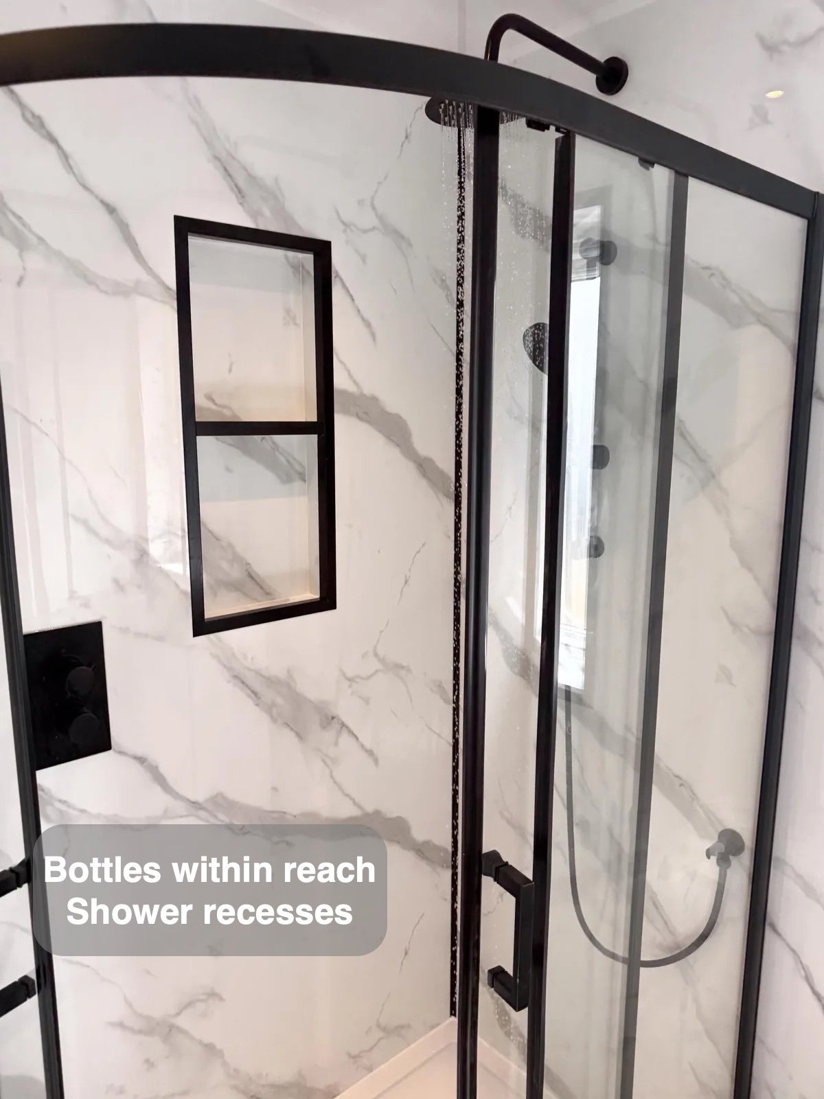 Black shower enclosure with recessed shelves