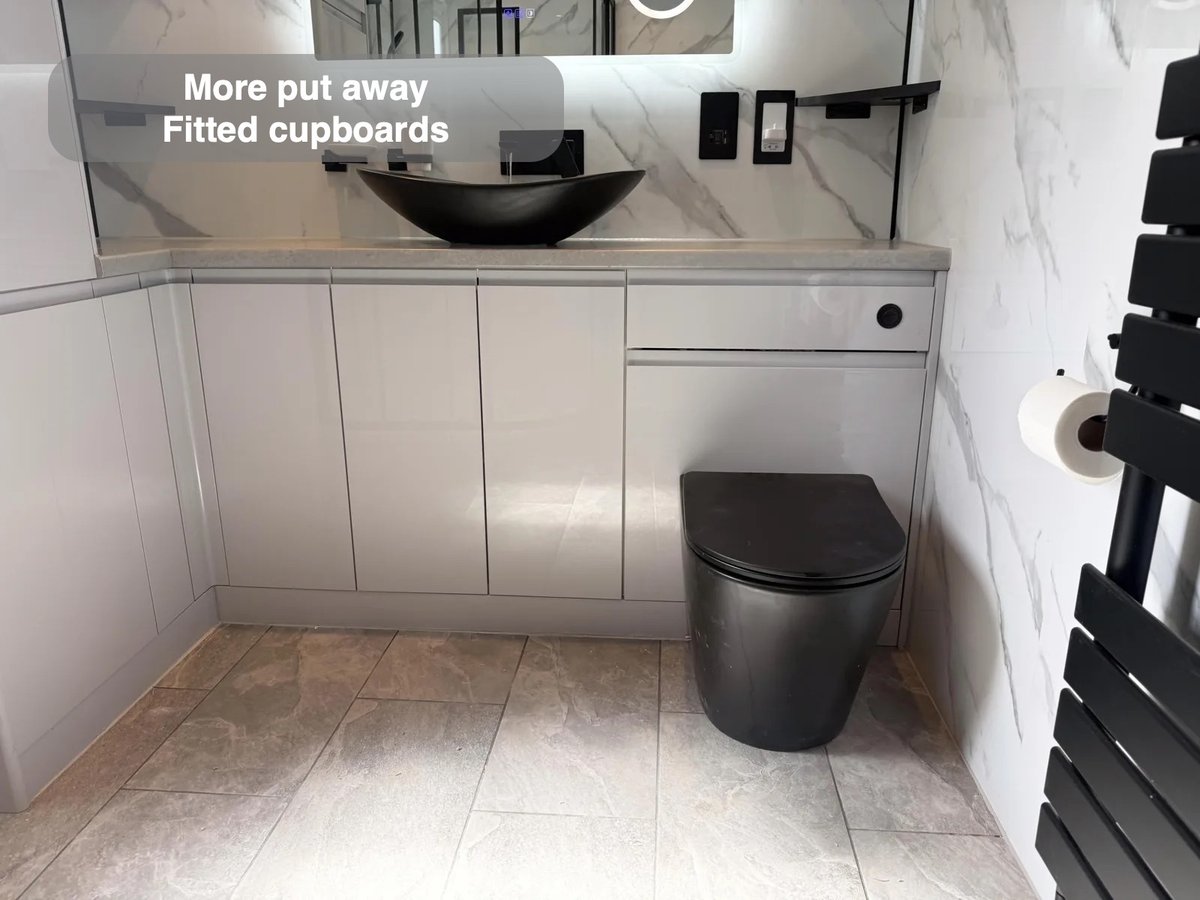 L-shaped fitted furniture around black toilet