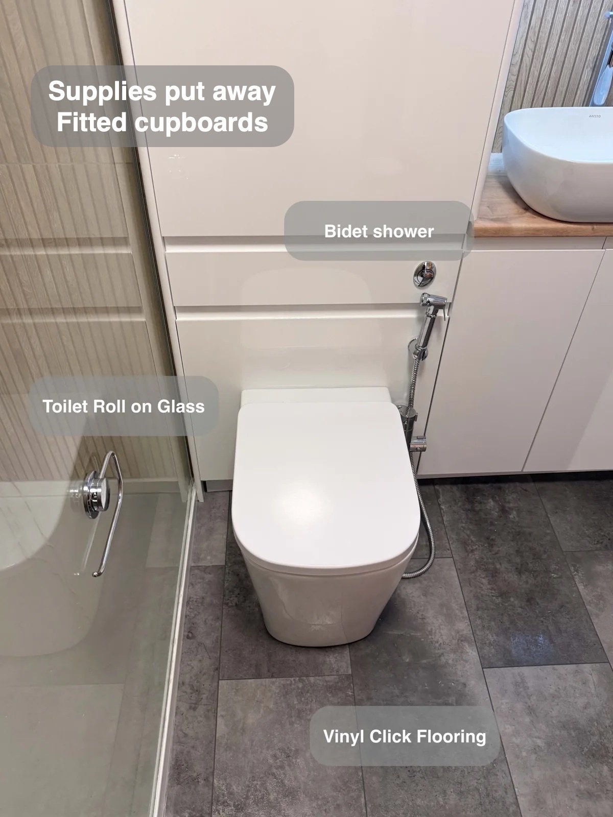 Toilet and bidet handset above vinyl flooring