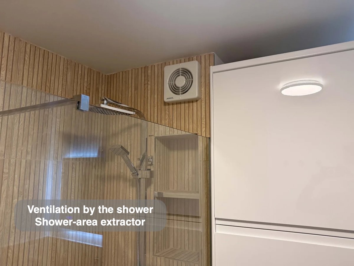 Extractor above glass screen beside tall cabinet