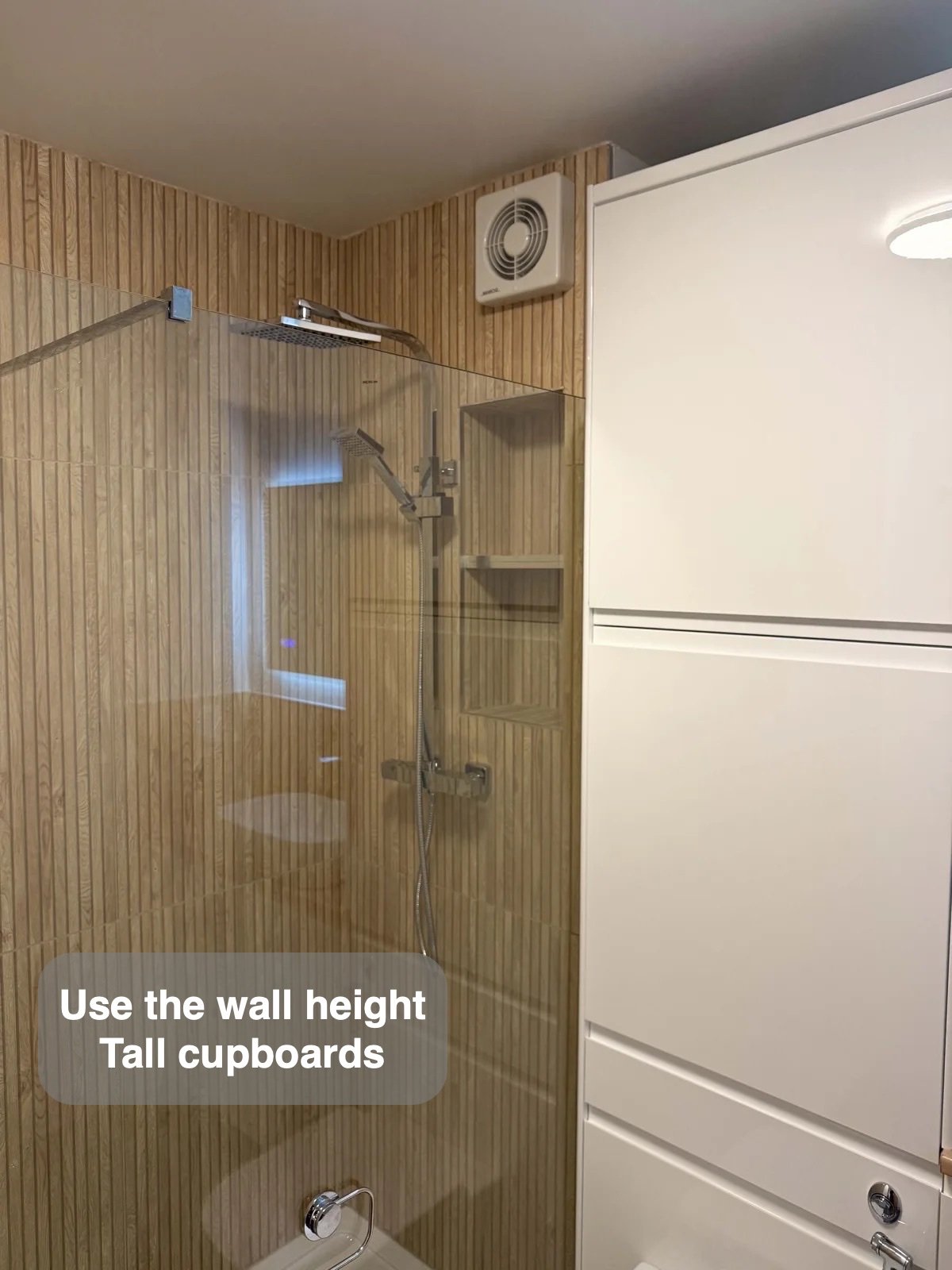 Tall white cupboards alongside shower