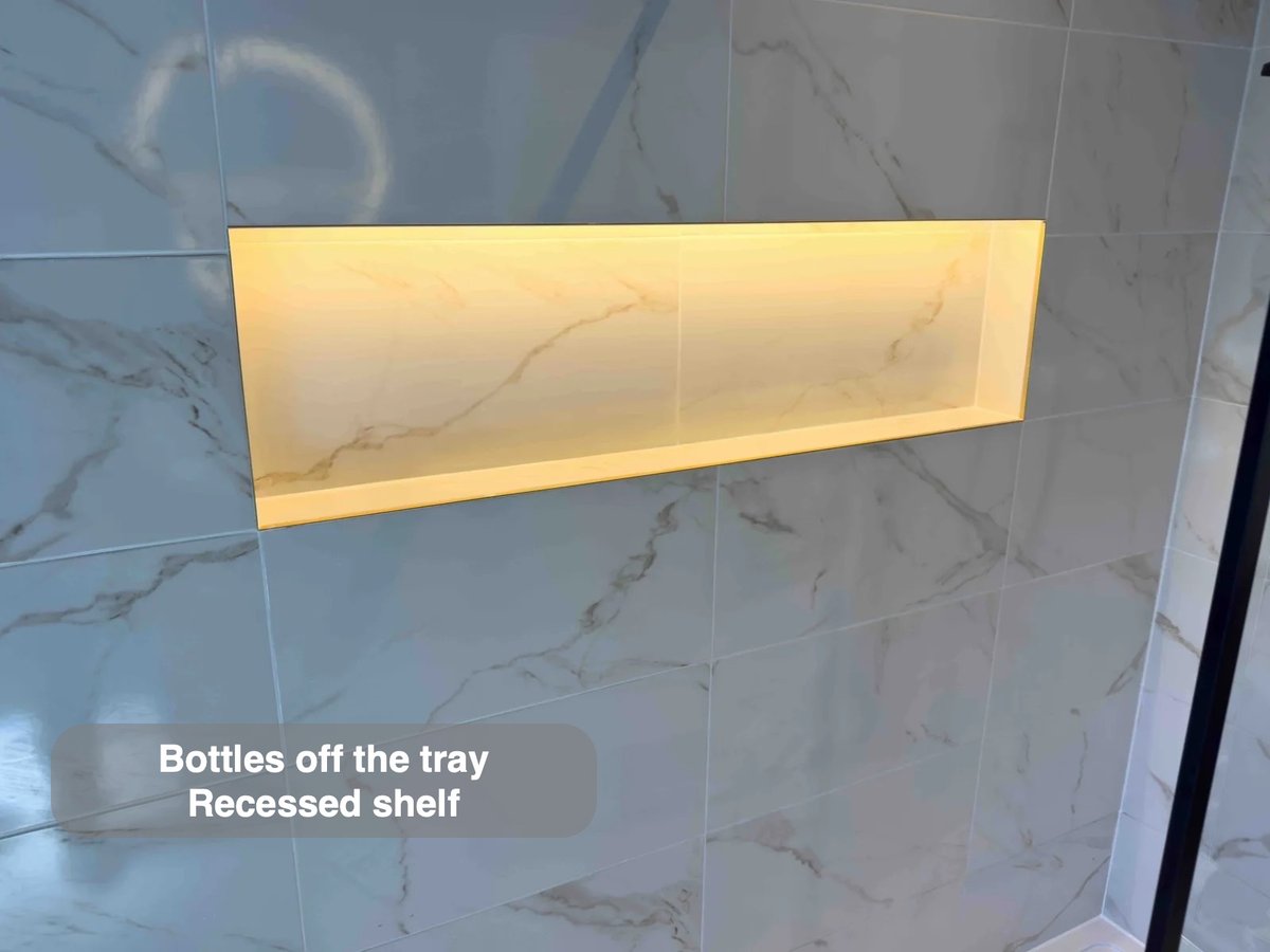 Illuminated storage recess in shower wall