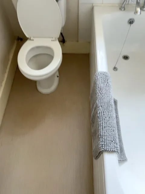 Original bathroom view showing bath and toilet
