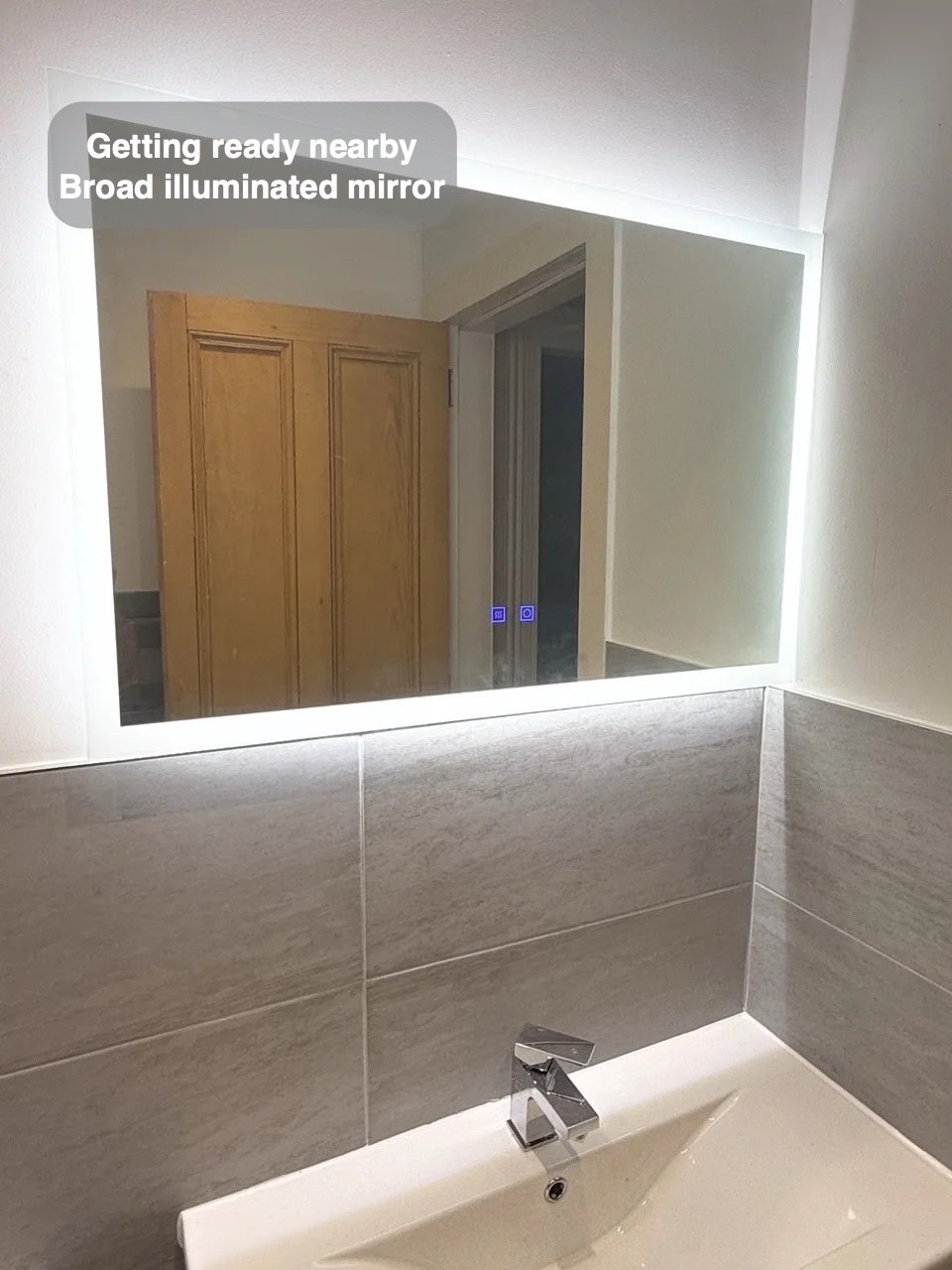 Large LED mirror above basin
