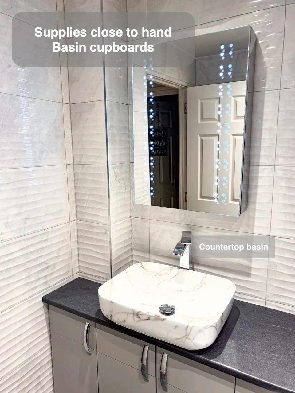 Basin beneath mirror cabinet