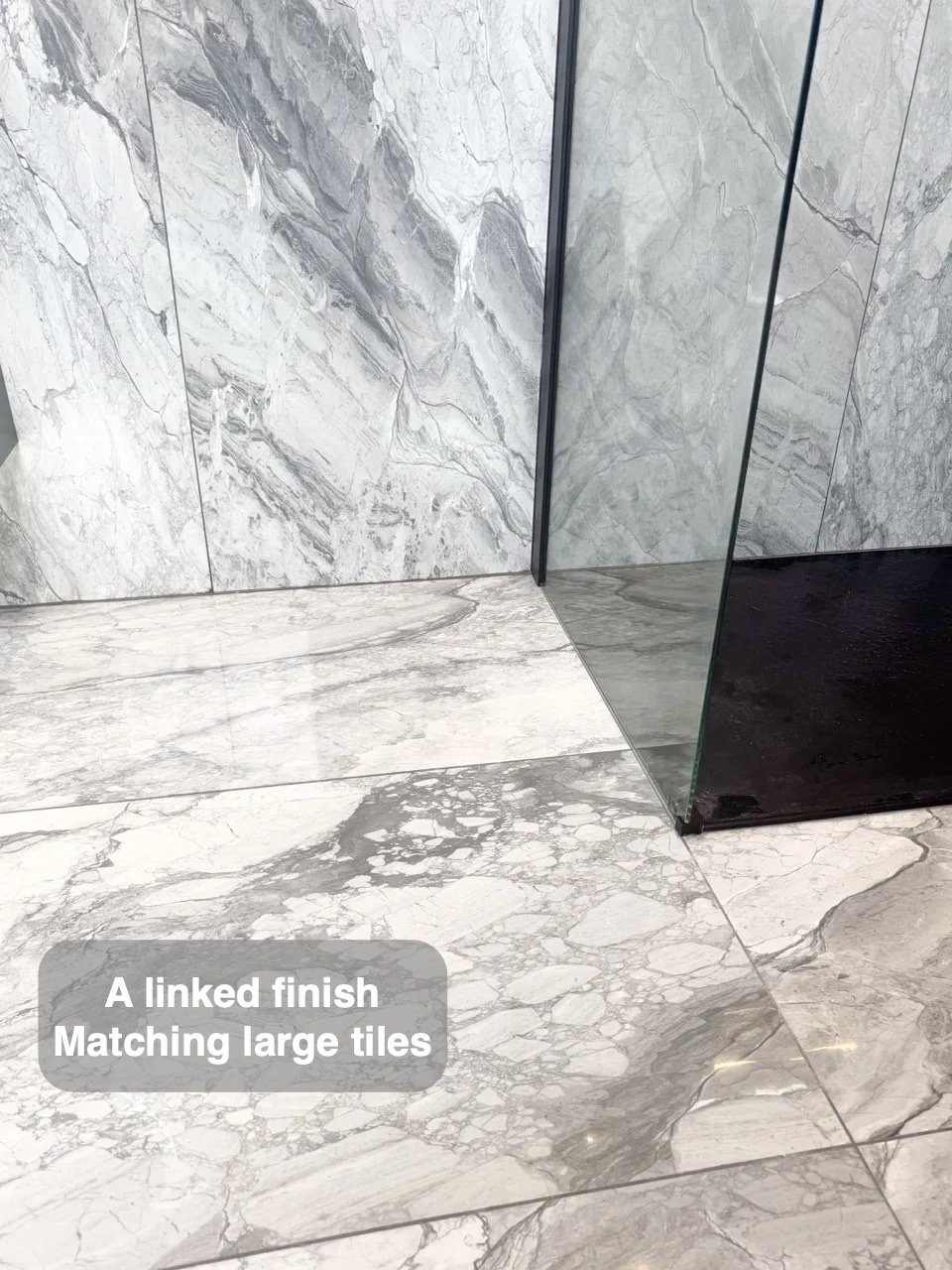 Tiled floor beside glass shower and bath