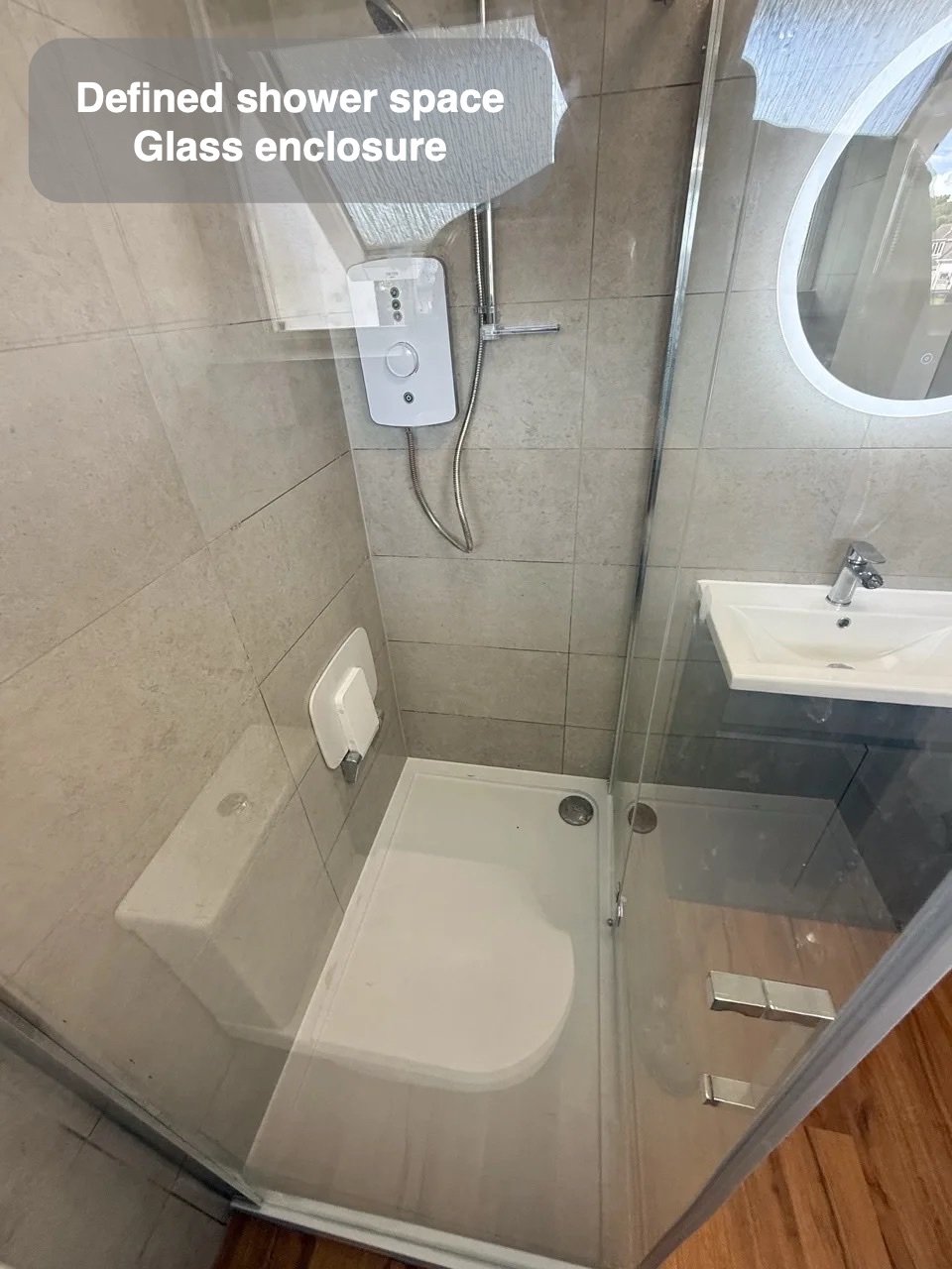 A defined shower with a folding seat in the completed Stoneywood, Aberdeen bathroom
