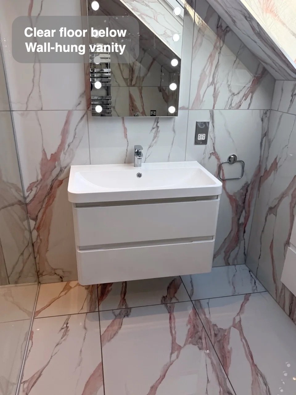Wall-hung vanity below illuminated mirror