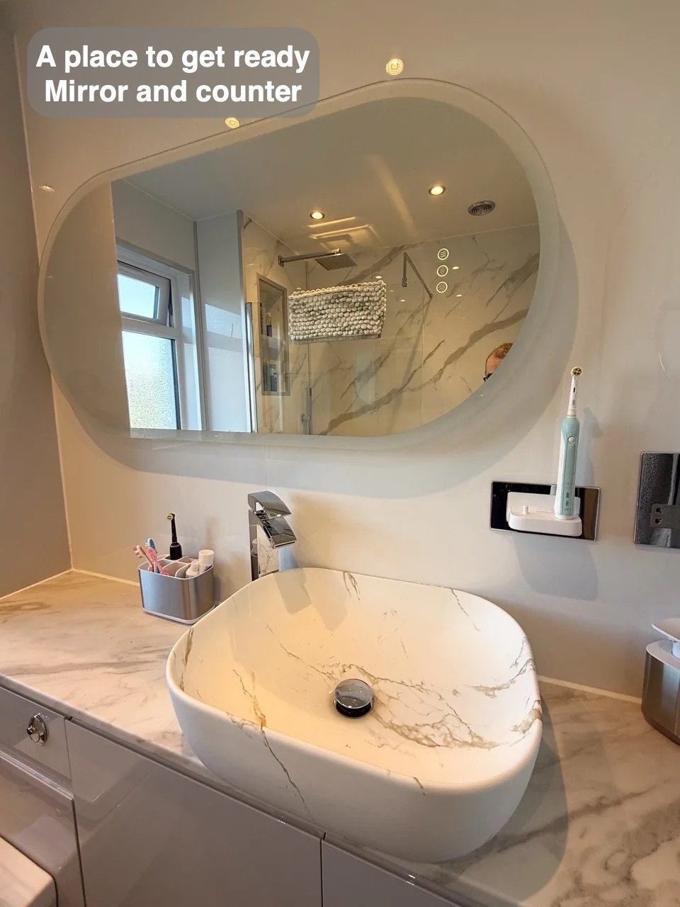 Countertop basin beneath illuminated mirror