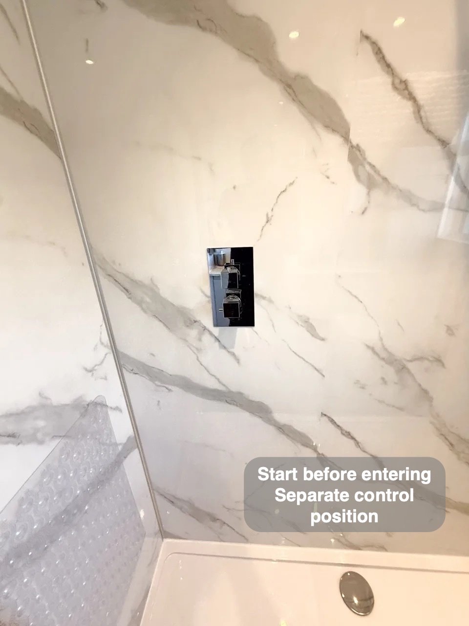 Concealed shower control on marble-effect panel