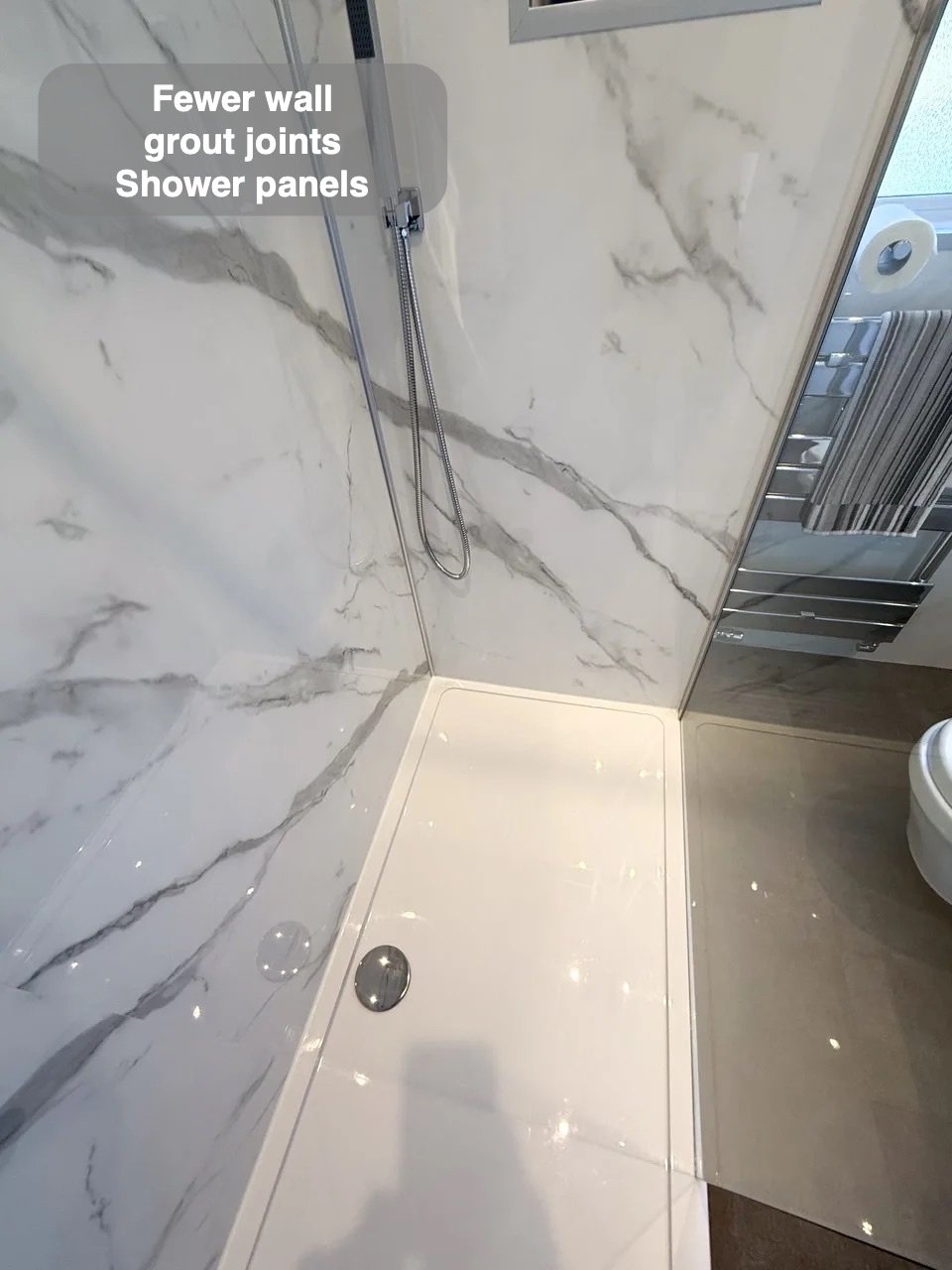 Shower tray beneath panelled walls and glass