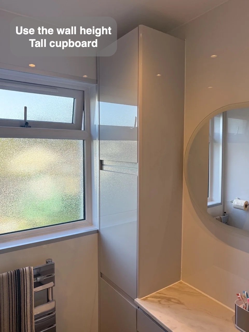 Tall storage unit beside window and mirror